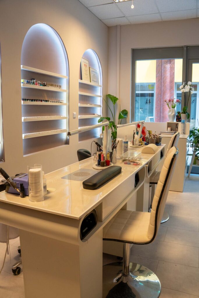 VANDIEURIST Nagelstudio von Innen mit 2 Tischen für die Nagelarbeit. Im Hintergrund mit Einzelnen Nagellackflaschen.