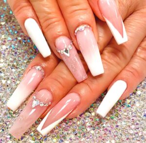 Ballerina Nägel in Perlweiß mit Einzeldesigns in Nude und Glitzersteinen als Highlight